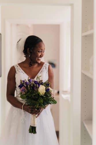 Wedding-preparation-photo-bride-smiles-in-white-dress-with-flowers