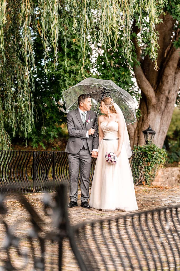 outdoor portrait of couple at the mill at Elstead in the rain