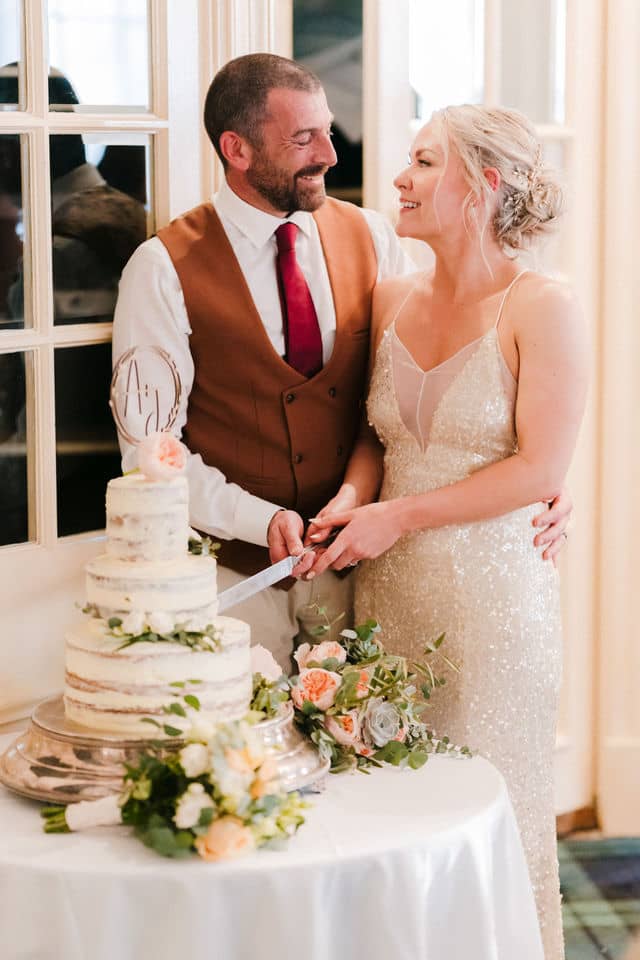 couple cutting the wedding cake at The Swan Hotel, Bibury