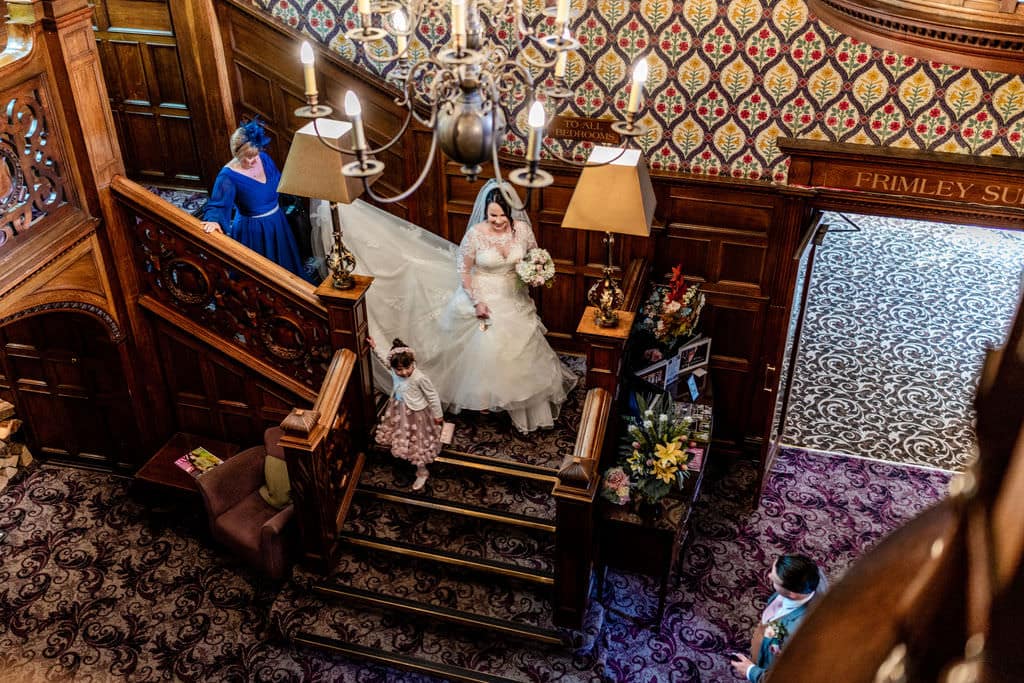 Bride walks down the stairs in Surrey Hotel