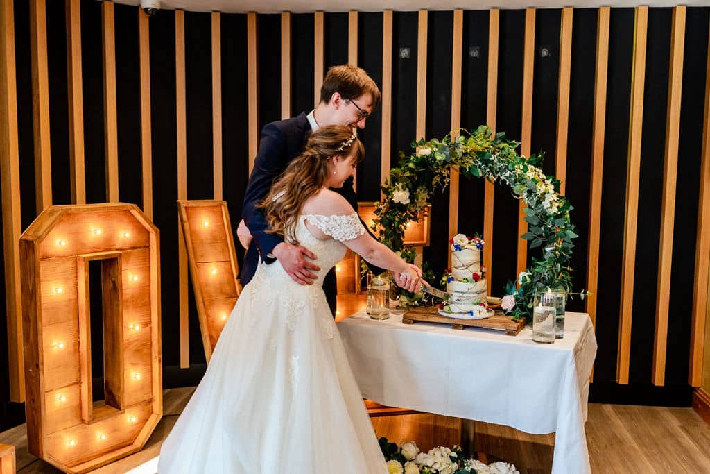 bride and groom cutting cake at Frensham Pond Hotel & Spa